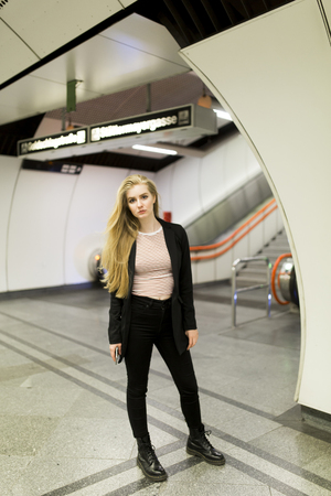 Young woman standing on a subway station, waiting for metroの写真素材