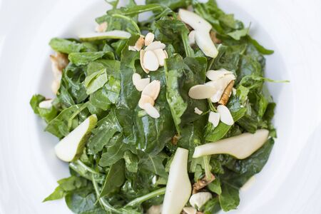 Close up view at spinach salad with pear and almondの写真素材