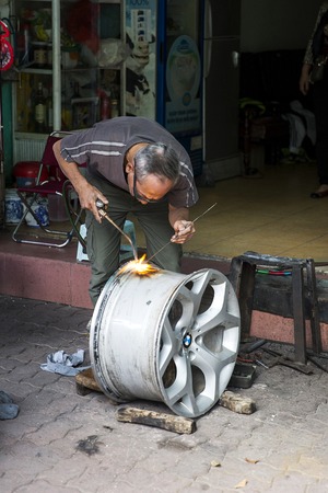 HANOI, VIETNAM - MARCH 2, 2017: Unidentified man at workshop on the street of Hanoi, Vietnam. Hanoi is capital of Vietnam and have more than 7,5 million citizens.のeditorial素材