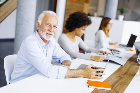 Senior  businessman and young businesswoman working together in office.の写真素材