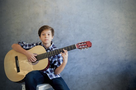 Portrait of Teen boy playing acoustic guitar