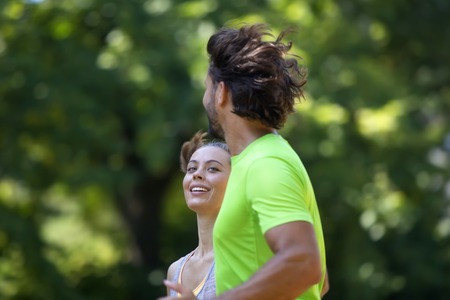 Healthy, fit and  sportive couple running in park at summer morningの写真素材