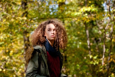 Portrait of curly hair teen girl in autumn forestの写真素材