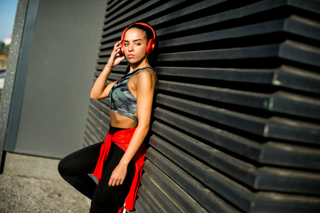 Attractive female  runner taking break after jogging outdoorsの写真素材