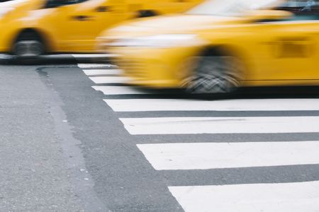 Abstract blur of urban street scene with a yellow taxi cab in New York, United Statesの写真素材