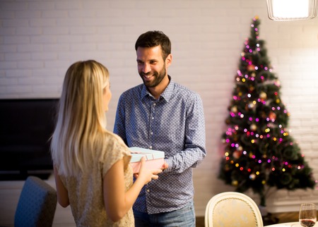Happy young couple with present at Christmas timeの写真素材