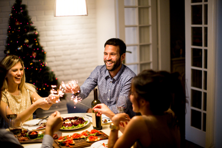 Friends celebrating Christmas or New Year eve at homeの写真素材