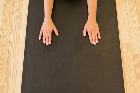 Woman doing yoga in studio on floorの写真素材