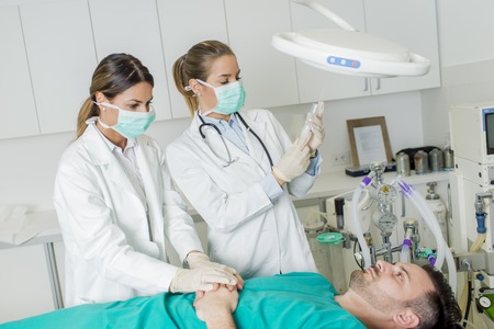 Female doctors preparing male patient for intervention in the hospitalの写真素材