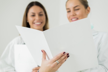Female doctors with file in hands, focus on file.の写真素材