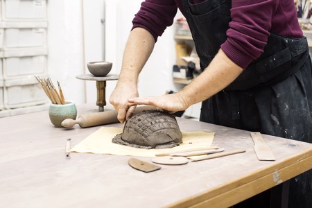Cllose up view at skilled master preparing clay workpieces for new his creations