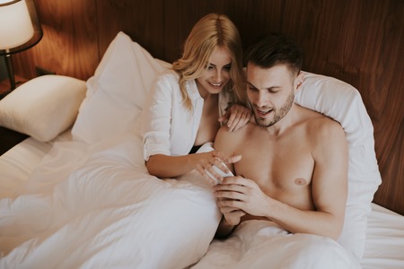 Loving and hugged couple on the bed in the room