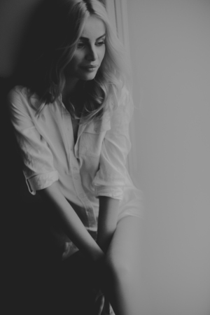 Top view at blond woman sitting by window at day lightの写真素材