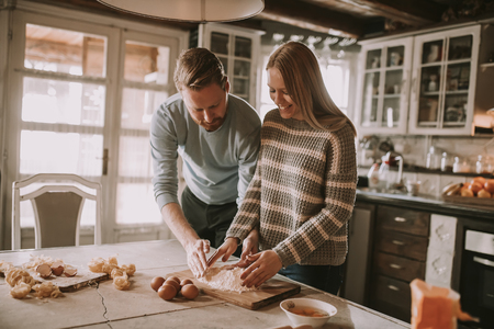 Loving couple preparing pasta in the kitchen at homeの写真素材