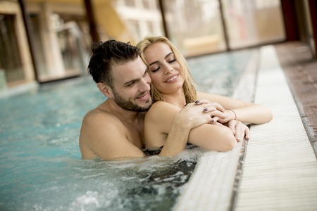 Loving couple relaxing in the pool at spa centerの写真素材