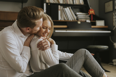 Happy and loving couple kissing in the room