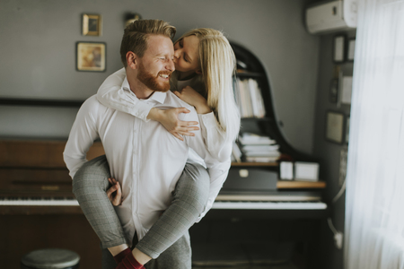 Happy and loving couple kissing in the roomの写真素材