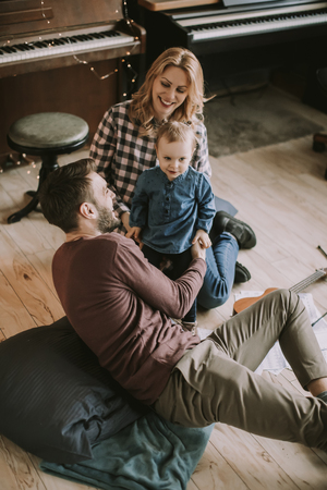 Happy young family playing on the floor  in the roomの写真素材