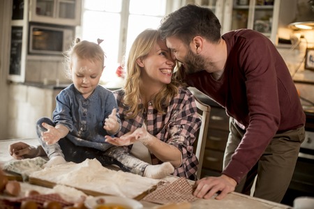 Happy family making pasta in the kitchen at homeの写真素材