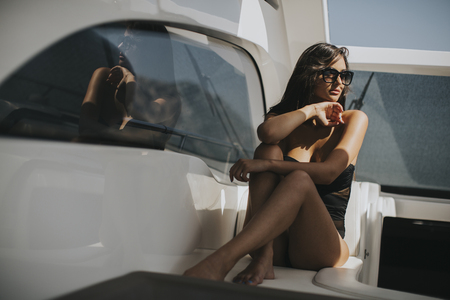 View at pretty young woman relaxing on the yacht at sunny dayの写真素材