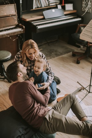 Happy young family playing on the floor  in the roomの写真素材