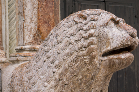 View at sculpture of lion with pray in front of Duomo in Modena, Italyの写真素材