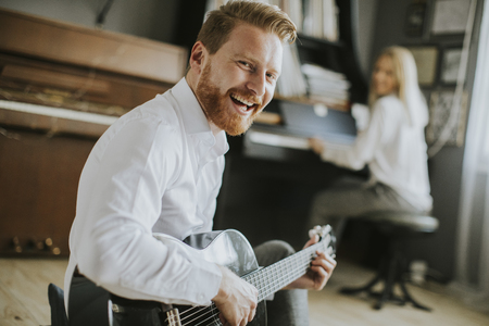 Young piano player accompanied by a handsome male guitaristの写真素材
