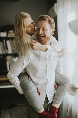 Happy and loving couple kissing in the room