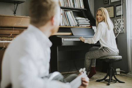 Young piano player accompanied by a handsome male guitaristの写真素材