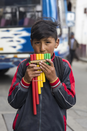 LA PAZ, BOLIVIA - JANUARY 12, 2018: Unidentified boy with pan flute at street of La Paz, Bolivia. At an elevation of 3650 m La Paz is the highest capital city in the worldのeditorial素材