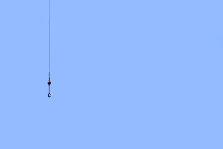 Lifting hook on a crane under blue skyの写真素材