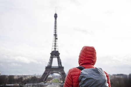 Young man with backpack looking at Eiffel tower in Paris, Franceの写真素材