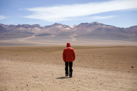 Young man at Dali desert at Eduardo Avaroa Andean Fauna National Reserve in Boliviaの写真素材