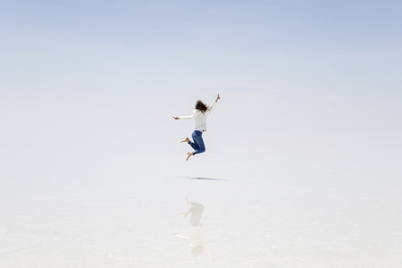 Young woman at Salar de uyuni salt flat in Boliviaの写真素材