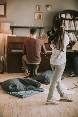Cute brunette little girl holding an photo camera in the roomの写真素材