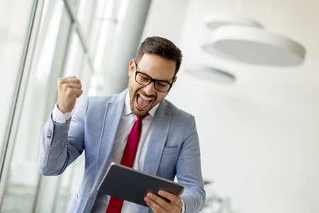 Portrait of young businessman with digital tablet in officeの写真素材