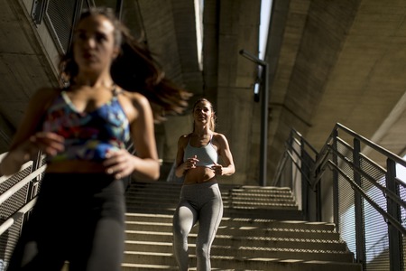 Young women running alone down stairs  outdoor in urban environmentの写真素材