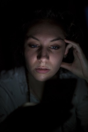 Portrait of young woman using mobile phone  late at night