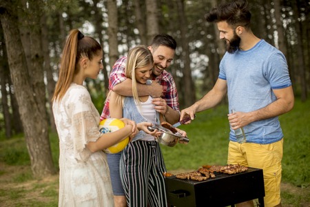 Group of young people enjoying barbecue party in the natureの写真素材