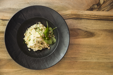 Top  view at risotto with gem fit and levisticum celery on a wood table compositionの写真素材