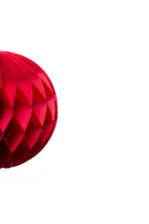 Red honeycomb pom-pom paper ball decoration isolated on white backgroundの写真素材