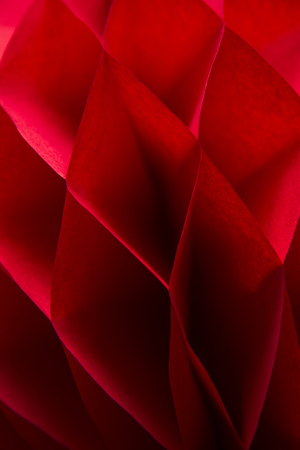 Closeup detail of the red honeycomb pom-pom paper ball decorationの写真素材