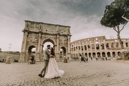 Young wedding couple by Arch of Constantine in Rome, Italy