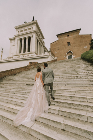 Loving bride and groom walking outdoors at Spagna Square and Trinita' dei Monti in Rome, Italyの写真素材