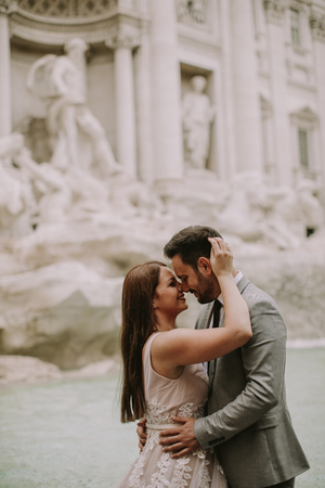 Just married bride and groom posing in front of Trevi Fountain (Fontana di Trevi), Rome, Italyの写真素材