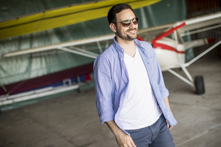 Handsome young man in the airplane hangarの写真素材