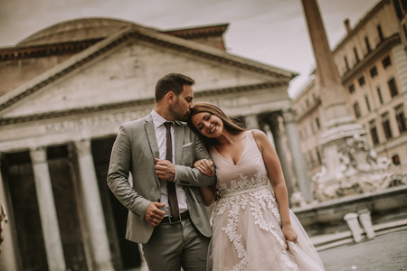 Young attractive newly married couple  posing in Rome with beautiful and ancient architecture in the backgroundの写真素材
