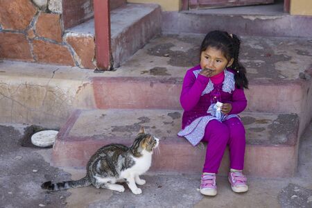 COPACABANA, BOLIVIA - JANUARY 6, 2018: Unindentified girl with cat on the street of Copacabana, Bolivia. Copacabana is the main Bolivian town on the Lake Titicacaのeditorial素材