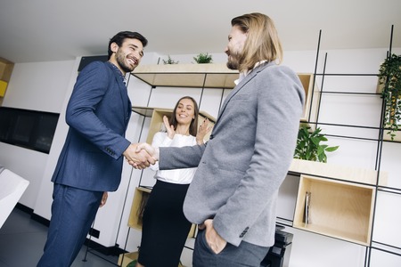 Businessmen handshaking after deal agreement in the officeの写真素材