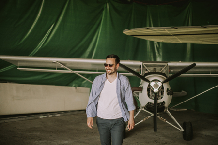 Handsome young man in the airplane hangarの写真素材